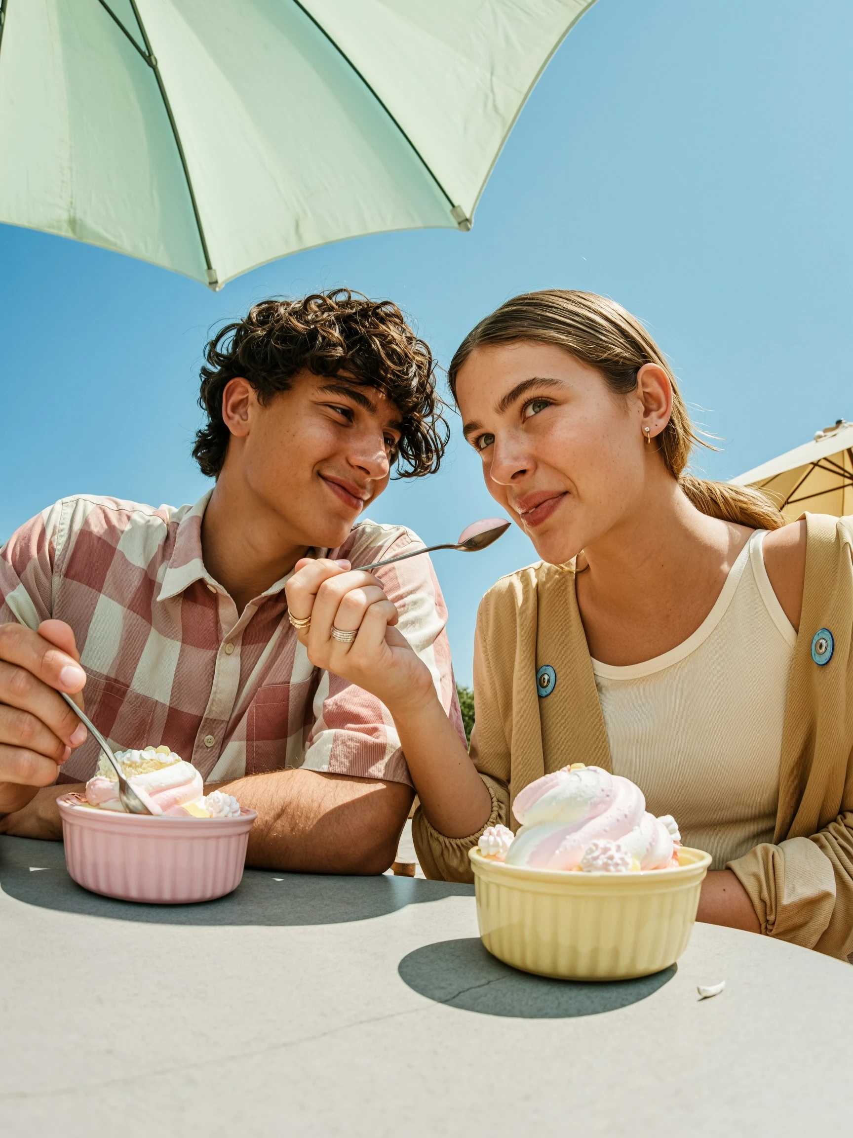 Wan 2.7 Text-to-Image-Pro: two young people eating dessert together, close-up shot, wide angle lens, exaggerated perspective, sitting at 