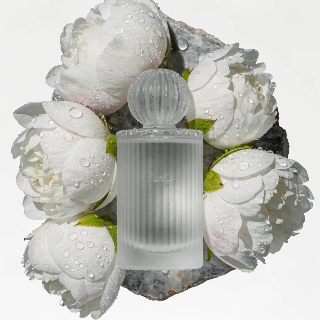 Recraft V4 Text-to-Image: A frosted glass perfume bottle on a slab of raw marble, surrounded by scattered white peonies and morning dew